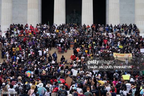 People attend the "Commitment March: Get Your Knee Off Our Necks" protest against racism and police brutality, on August 28 at the Lincoln Memorial...