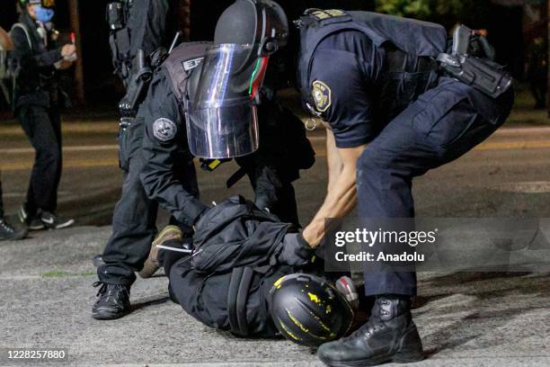 About two hundred persons protesting police brutality spray graffiti and start fires at the Portland Police Union building, in Portland, Oregon,...