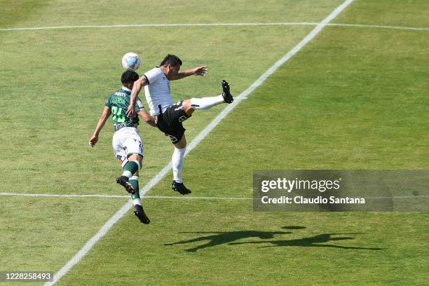 Esteban Paredes of Colo-Colo heads the ballon against Luis Garcia of Santiago Wanderers during a match between Colo-Colo and Santiago Wanderers as...