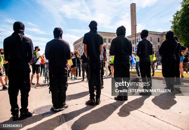 Demonstrators dressed in black march with the family of Jacob Blake during a rally against racism and police brutality in Kenosha, Wisconsin, on...