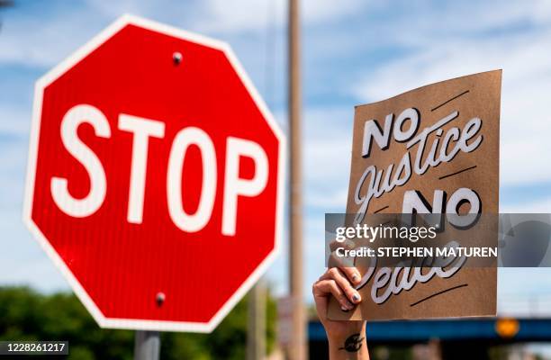 Person holds up a sign before a march in honor of Jacob Blake and against racism and police brutality in Kenosha, Wisconsin, on August 29, 2020. -...