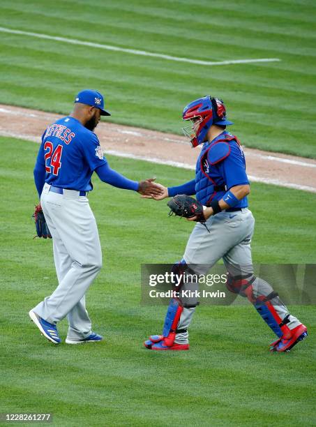 Jeremy Jeffress of the Chicago Cubs is congratulated by Victor Caratini after getting the final out and completing the save against the Cincinnati...