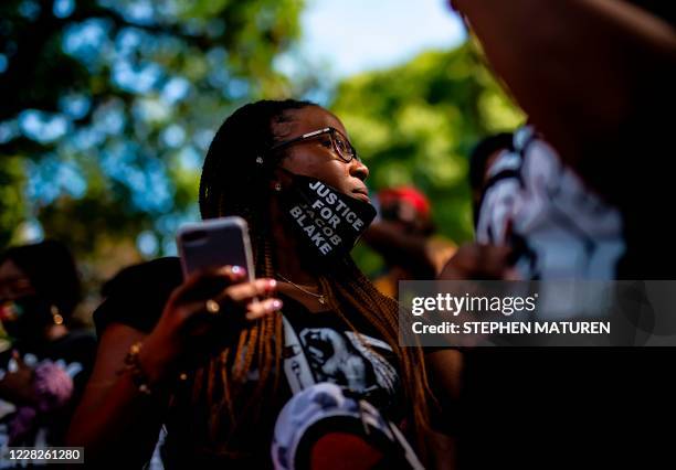 Demonstrators gather to hear from the family of Jacob Blake outside the Kenosha County Courthouse during a rally against racism and police brutality...