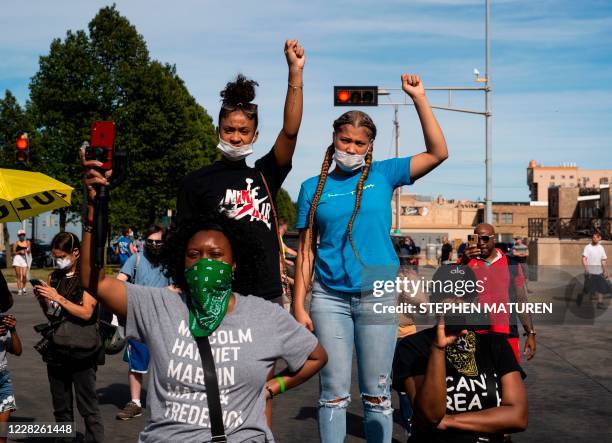 Demonstrators raise their fists as speakers talk about the shooting of Jacob Blake during a rally against racism and police brutality in Kenosha,...