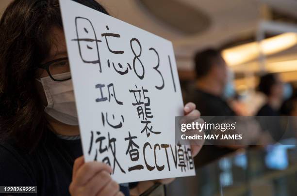 Protestor holds a placard that reads "do not forget 831 terror attack, truth needs to be seen on CCTV" during a demonstration at a mall on the eve of...