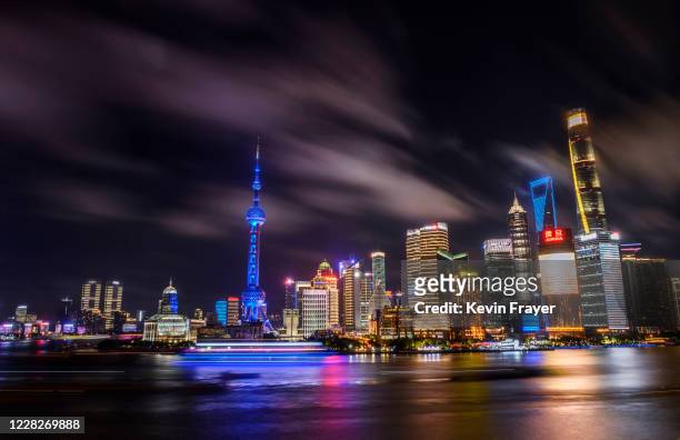 Boats travel on the Huangpu River as the skyline of the city in the Pudong district is seen on August 29, 2020 in Shanghai, China.