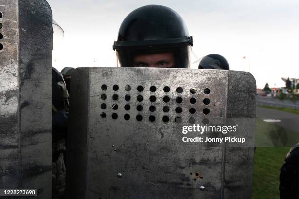 Riot Police stand guard at the Palace of Independence, Lukashenko working residency, as tens of thousands march towards them to protest against...