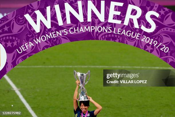 Lyon's Japanese midfielder Saki Kumagai holds the trophy upon her head as she celebrates after Lyon won the UEFA Women's Champions League final...