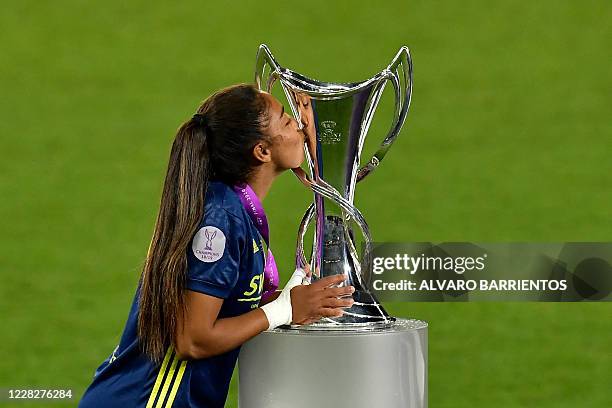 Lyon's French defender Selma Bacha kisses the winner's trophy as she celebrates with teammates after winning the UEFA Women's Champions League final...