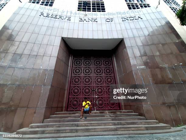 Man watch on Mobile at front of closed Reserve Bank of India during the biweekly Lockdown in the wake of COVID-19 pandemic in Kolkata on August...