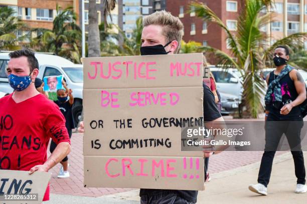 Participants march from Durban beachfront to Durban City Hall during the #EndTheFemicide protest on August 29, 2020 in Durban, South Africa. It is...
