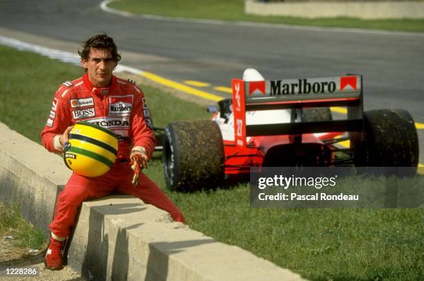 Ayrton Senna of Brazil sits on a wall next to his McLaren Honda during the Spanish Grand Prix at the Jerez circuit in Spain. Senna retired from the...