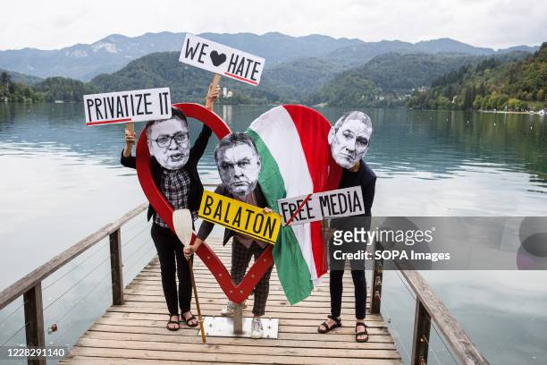 Protesters wearing paper masks showing the faces of Slovenian Prime Minister, Janez Jansa, Hungarian Prime Minister, Viktor Orban and Serbian...