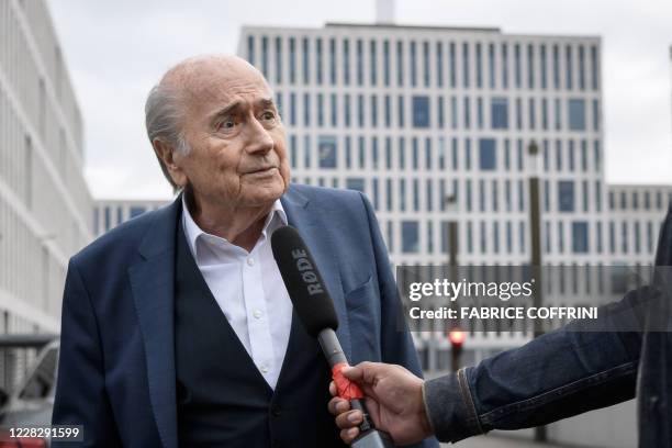 Former president of World football's governing body FIFA, Sepp Blatter speaks to a journalist as he arrives at the building of the Office of the...