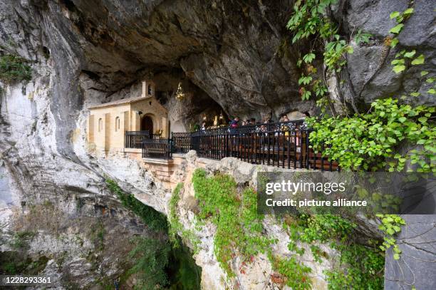 August 2020, Spain, Covadonga: Tourists stand in the Holy Cave at the shrine of the Virgin Mary. Photo: Sebastian Kahnert/dpa-Zentralbild