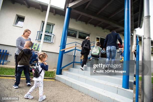 Parents bring their children to school during the first day of the new school year. Despite a rise in COVID-19 infections after summer vacations, the...