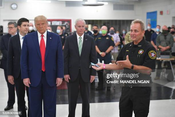 President Donald Trump listens to Kenosha County Sheriff David Beth on September 1 at Mary D. Bradford High School in Kenosha, Wisconsin. - Trump...