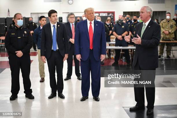 President Donald Trump listens to Republican Senator Ron Johnson during a tour of an emergency operations center at Mary D. Bradford High School in...