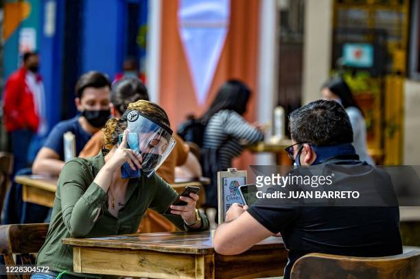 People wear face masks and shields during a pilot test of restaurant opening in Chorro de Quevedo tourist area, in Bogota on September 1 during te...