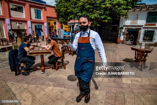 Waiter works during a pilot test of restaurant opening in Chorro de Quevedo tourist area, in Bogota on September 1 during te coronavirus pandemic. -...