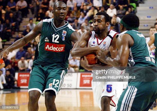 Le joueur du CSKA Moscou, Robert Holden , tente de passer les deux joueurs de Villeurbanne, Sacha Giffa et Stevin Smith, le 31 octobre 2002 à...