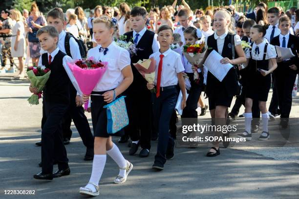 Elementary school students in the school line with flowers during the celebration. A "Freshman day" was organized at the Music Square where a school...