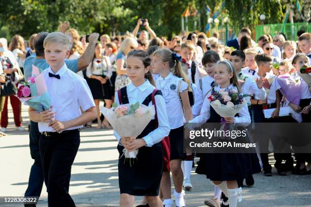 Elementary school students in the school line with flowers during the celebration. A "Freshman day" was organized at the Music Square where a school...
