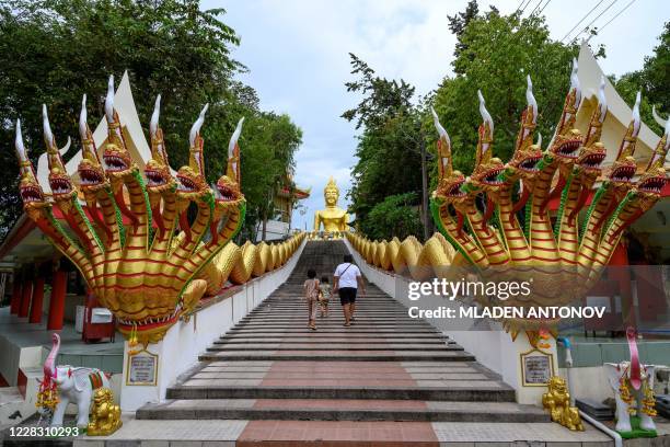 Visitors climb the stairs leading to the Big Buddha statue at the Wat Phra Yai Temple in Pattaya on September 2, 2020.