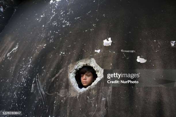 Palestinian child checks a house that was ablaze taking the life of three children after a fire was ignited by a candle used to light up their room...