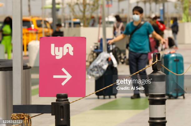 Passengers connect with drivers at the Rideshare Lot at LAX as Uber and Lyft drivers held a moving rally as part of a statewide day of action to...