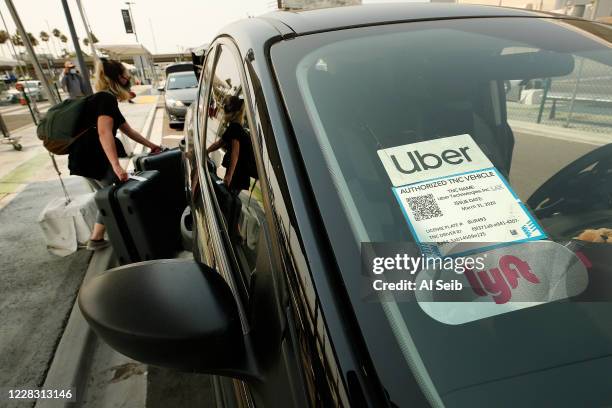 Passengers connect with drivers at the Rideshare Lot at LAX as Uber and Lyft drivers held a moving rally as part of a statewide day of action to...