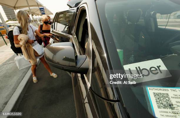 Passengers connect with drivers at the Rideshare Lot at LAX as Uber and Lyft drivers held a moving rally as part of a statewide day of action to...