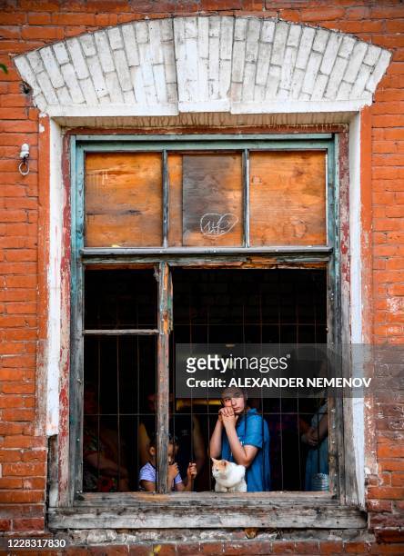 Girl looks out from a window in a dormitory for the workers of Proletarka textile factory in the town of Tver, 200 kilometres north-west from Moscow...