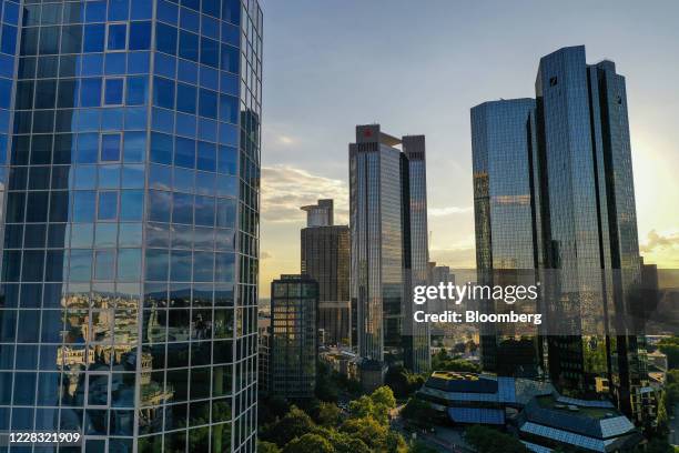 Sunlight reflects off the Deutsche Bank AG twin tower headquarters, right, beside the Frankfurter Sparkasse Tower, center, on the financial district...