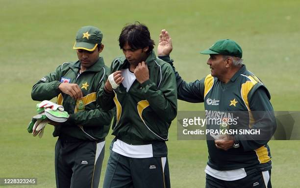 Pakistan's cricket team coach Intikhab Alam gestures while talking with Mohammad Asif and Umer Akmal during the training session at Wanderers Stadium...