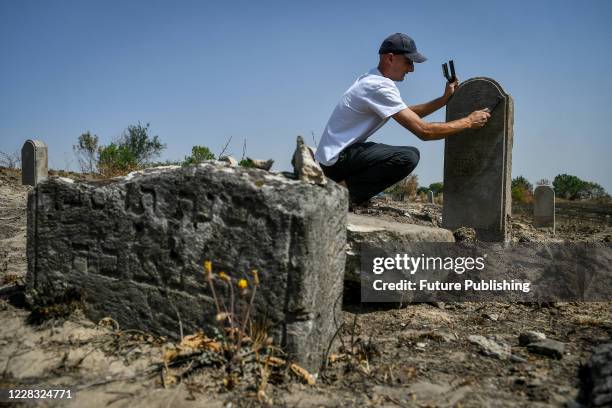 Activist of the "Riton" Scientific and Research Historico-Archaeological Association Yevhen Khmelievskyi is pictured at the Old Jewish cemetery being...