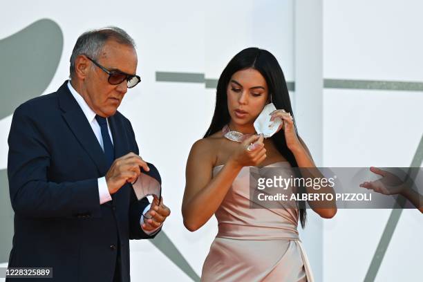 Director of the Venice Film festival, Alberto Barbera and Argentinian-Spanish model and actress Georgina Rodriguez take off their face mask as they...