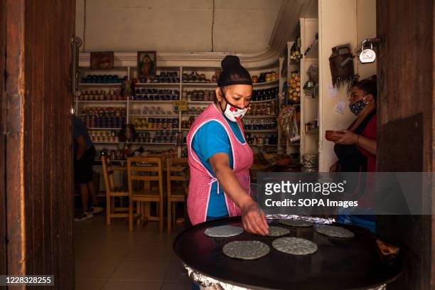 Worker makes Mexican corn tortillas outside a restaurant. Even though the number of visitors is not comparable with those before the Covid-19...