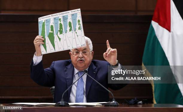 Palestinian president Mahmud Abbas holds a placard showing maps of historical Palestine, the 1937 Peel Commission partition plan, the 1947 United...