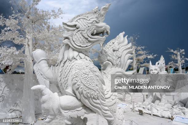 This photograph taken on September 2, 2020 shows sculptures of mythical creatures made of white sand imitating ice in the "Frost Magical Ice of Siam"...