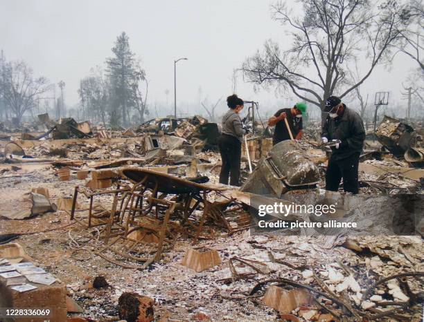 August 2020, US, Santa Rosa: Photographed from a tablet, the photo shows the Granger family searching for remains in the ashes of their burnt down...