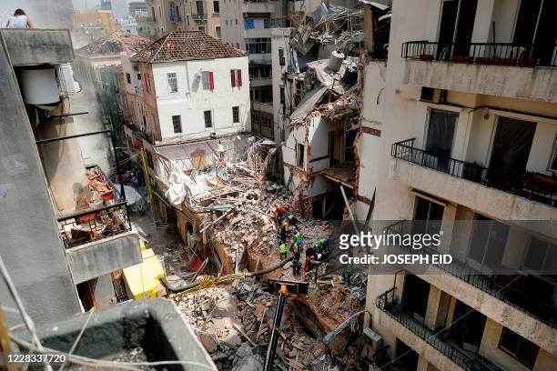 Rescue workers dig through the rubble of a badly damaged building in Lebanon's capital Beirut, in search of possible survivors from a mega-blast at...