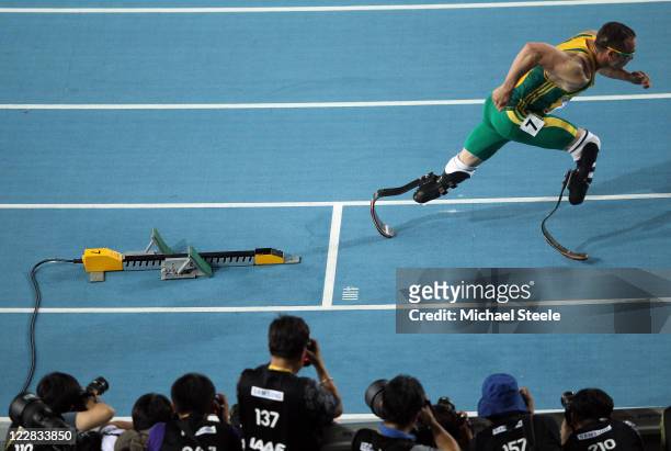 Oscar Pistorius of South Africa bursts out of the blocks in front of photographers at the start of the men's 400 metres semi finals during day three...