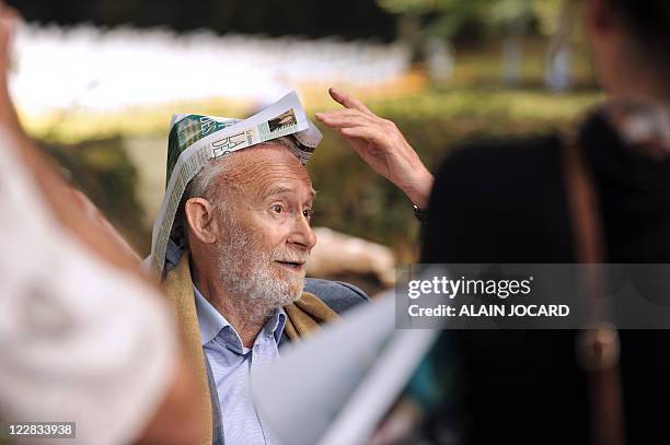 French cartoonist Piem aka Pierre de Barrigue de Montvallon wears a newspaper hat on August 28, 2011 in the French central city of...