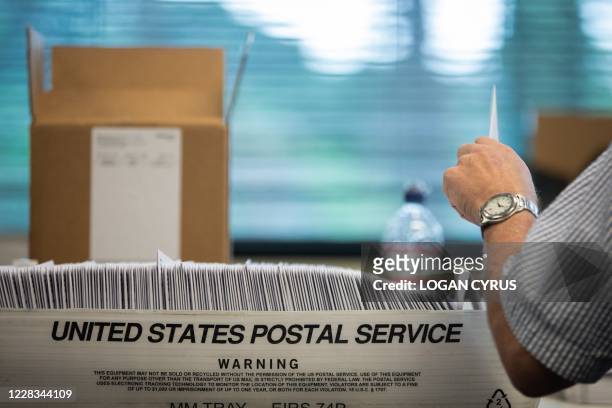 Absentee ballot election workers stuff ballot applications at the Mecklenburg County Board of Elections office in Charlotte, North Carolina on...