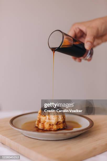 caramel sauce pouring out of a small glass on a dessert flan - pudim-de-leite imagens e fotografias de stock