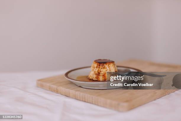 mexican dessert caramel flan styled on a small pottery plate on a white linen table - flan stock pictures, royalty-free photos & images