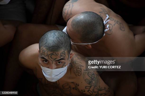 Members of the MS-13 and 18 gangs remain under custody as they sit on the floor during a search operation at the maximum security prison in Izalco,...