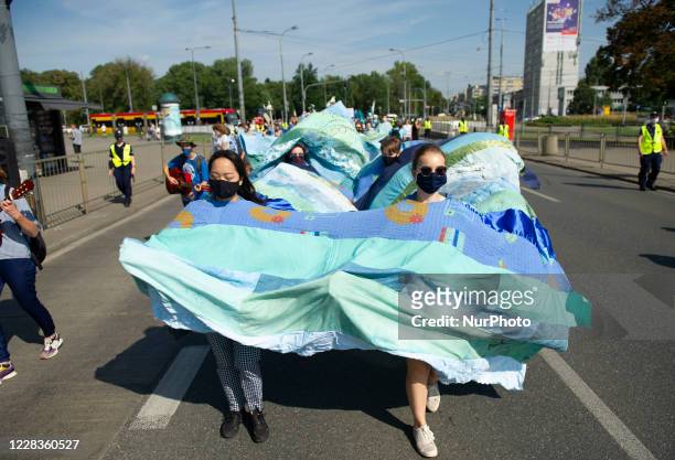 Demonstrators wear a fabric that illustrates a wave during the great march for climate on September 5, 2020 in Warsaw, Poland. A few thousand people...