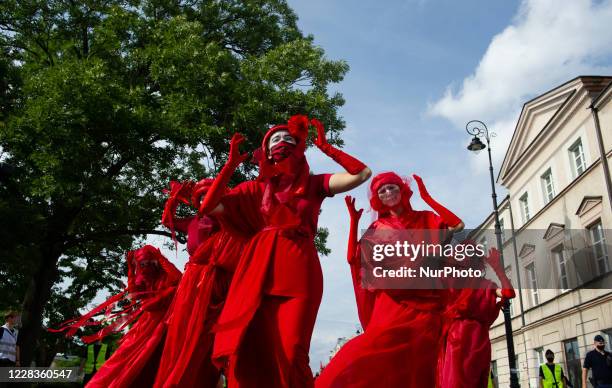 Extinction rebellion activists perform as Red Rebel Brigade during a march gainst climate change on September 5, 2020 in Warsaw, Poland. A few...